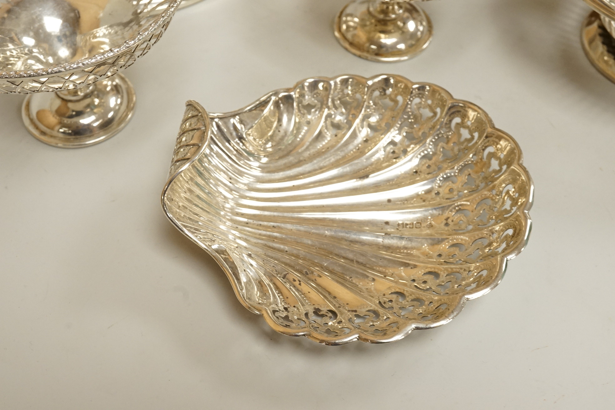 Two pairs of early 20th century silver bonbon dishes, including smallest by Mappin & Webb, Birmingham, 1913, height 6cm, together with an Edwardian silver butter shell and a pair of Edwardian silver mounted bottle coaste